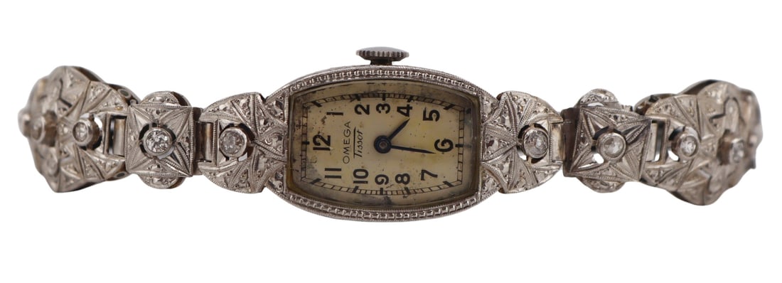 JEWELRY. Lady's Art Deco Omega Tissot Diamond: Watch. This watch features a platinum 14 mm watch case, with bezel-set diamond accents to the lugs. The articulated platinum bracelet is composed of six decorative segments, three on each side of the