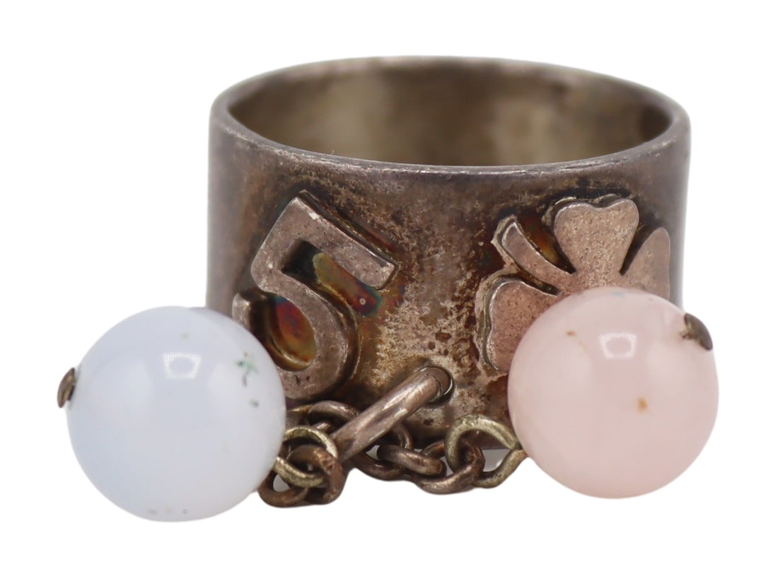 JEWELRY. Chanel French .925 Silver Ring with Bead: Accents. Chanel .925 silver wide band ring displaying an applied "5" and a four leaf clover, and further accented by two dangling round beads on chains. Beads measure approx. 10.0mm in diameter. Stamp