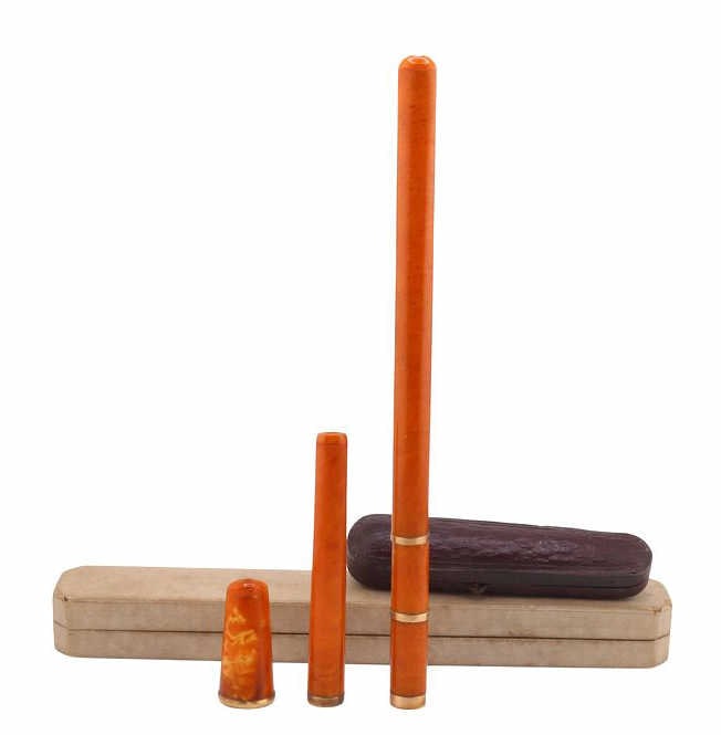 JEWELRY. (3) Assorted 14kt Gold Cheroot Holders: (1) unmarked 17kt yellow gold mounted amber cheroot holder - approx. 0.47" opening; (1) cased 14kt yellow gold mounted amber cheroot holder - stamped "14kt," approx. 0.31" opening; and (1) cased 14kt 