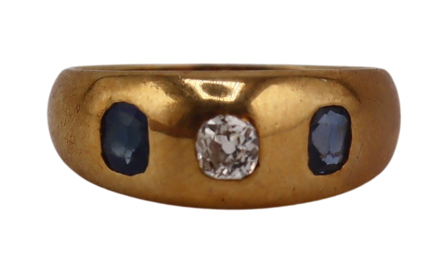 JEWELRY. 18kt Gold, Sapphire & Diamond Gypsy Ring.: Antique 18kt yellow gold gypsy ring displaying a central flush set Old Mine cut diamond flanked by (2) faceted sapphires on a tapered band. Total approx. weight of the ring is 2.8 dwt (gross). Ring si