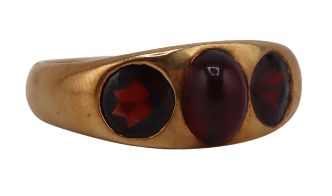 JEWELRY. Antique 15.5kt Gold and Garnet Ring.: Antique 15.5kt yellow gold tapered band ring displaying a central sugarloaf garnet cabochon flanked by (2) flush set round faceted garnets. Stamped, "18K" to the interior of the band. Total approx. we