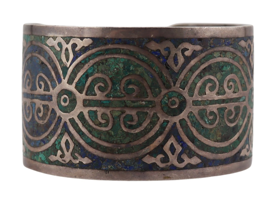 JEWELRY. Mexican Arte en Plate Sterling Bracelet.: Large Mexican Arte en Plate sterling cuff bracelet inlaid throughout with turquoise and lapis lazulis chips. Stamped to the interior, "Arte en Plate Mexico". Total approx. weight of the bracelet is 4.