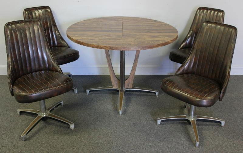 1970s Modern Dinette Set Including 4 Chairs.: Includes a round dining table on unique Danish modern style base with wood grain Formica top. All chairs have steel star bases and faux leather upholstery. All labeled and dated, Chromcraft 1974. From