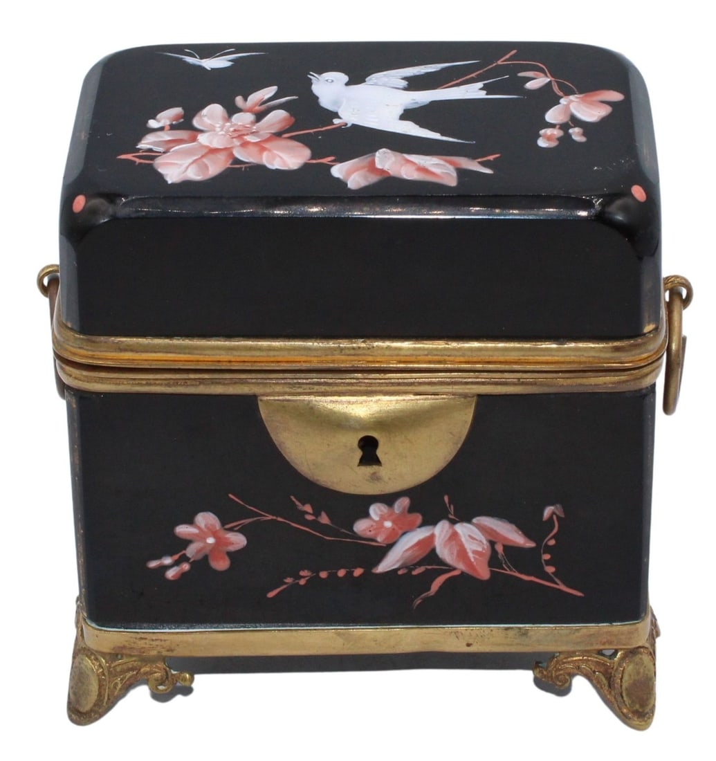 19th C Black Opaline Glass Box with Birds and: Pink Flowers. Black opaline box with brass mounts. Stamped, "67" on a leg. A gilt metal lock system. Decorated with white birds and pink flowers. Oval form feet and ring side handles. From t