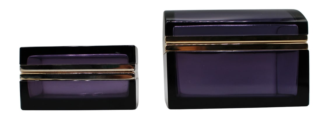 (2) Amethyst Colored Glass Boxes with Gilt Brass: Mounts. Including a rectangle formed amethyst colored glass box; and a trunk form amethyst colored glass box. From the estate of a 50+ year antique dealer specializing in decorative arts with an empha
