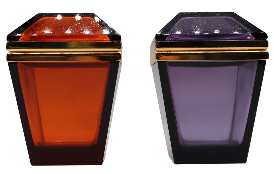 (2) Unusual Form Amethyst and Amber Midcentury: Glass Boxes. Including an amber colored mid century trapezoid form box with gilt metal mounts; and a French amethyst colored glass trapezoid form glass box with gilt metal mounts. From the estate of a