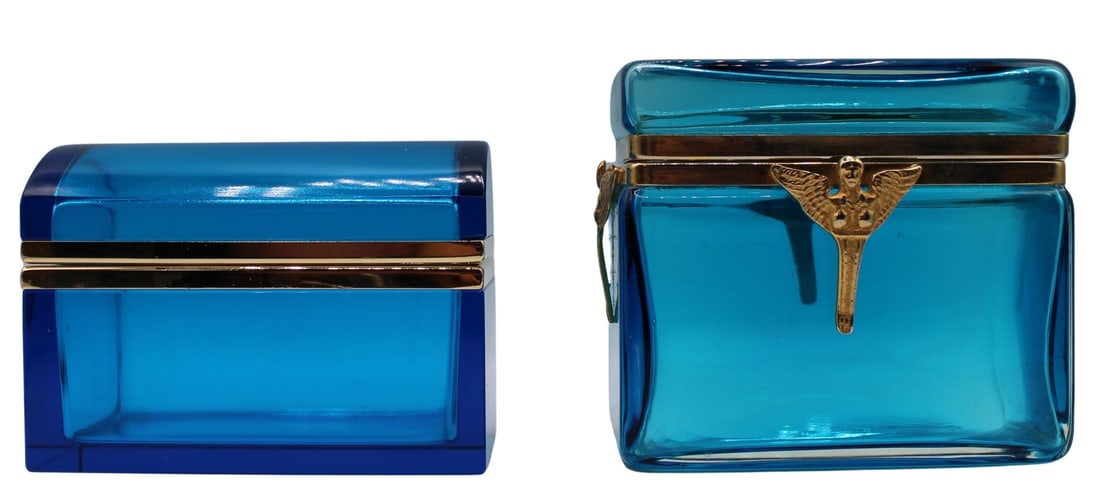 (2) Midcentury Blue Glass Boxes with Metal Mounts.: Including a midcentury electric blue glass box with gilt metal mounts; and an Egyptian revival peacock blue glass box with bronze mounts. The Egyptian box is decorated with (4) women with wings. From 