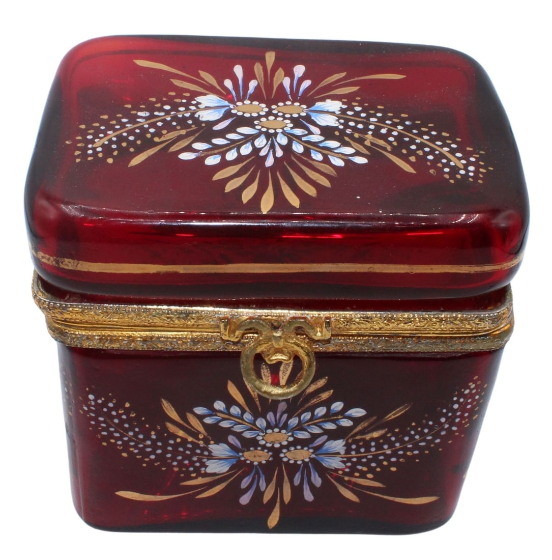 Enamel Decorated Ruby Red Glass Box.: Ruby red glass box is decorated in a gold and blue floral motif with engraved gilt metal mounts and a ring form front latch. From the estate of a 50+ year antique dealer specializing in decorative