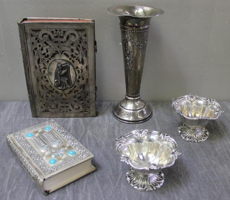 JUDAICA. Miscellaneous Silver Lot.: Includes a weighted floral vase with floral decoration, a siddur with a silver cover, a pair of small English silver dishes, and an Austria-Hungary silver book cover depicting Moses holding the 10 com