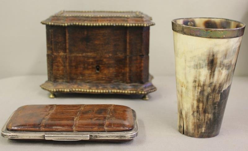 Miscellaneous Lot Includes a Fitted Ink or Cologne: Bottle Set in Brass Trimmed Box. Together with a silver mounted horn cup, an English silver mounted hide cigar case with hallmarks and inscribed Henry Wilson 60 Pall Mall, also stamped patent clasp. F