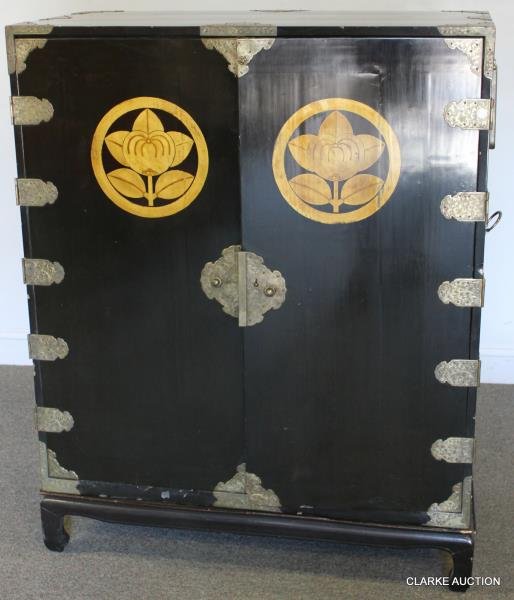 Magnificent Japanese Lacquered Cabinet: On Conforming Stand. Engraved brass mounted with simple gilded flower design to front doors. Gold family crests on doors. Fitted interior. Meticulously maintained. Accompanied by identification docume