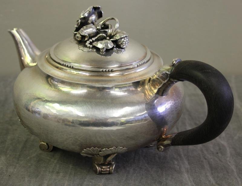 STERLING. Georg Jensen "Rose" Teapot, No. 262.: With applied floral and foliate finial on scroll feet. Total approximate weight is 27.71 troy oz, including the ebony or wood handle. From a Scarsdale, NY estate. Please note that this lot was previou