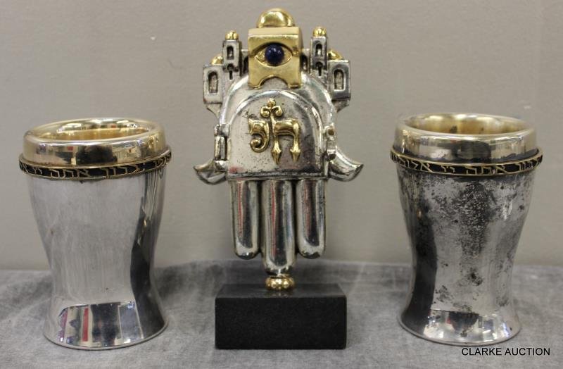 Frank Meisler Sculpture "Good Luck Charm".: With a pair of unmarked probably silverplate kiddush cups with brass borders. From a Bronx, NY estate. Dimensions: Meisler - 7" h; Cups 4.5" h. Condition: Good some tarnish to one cup.