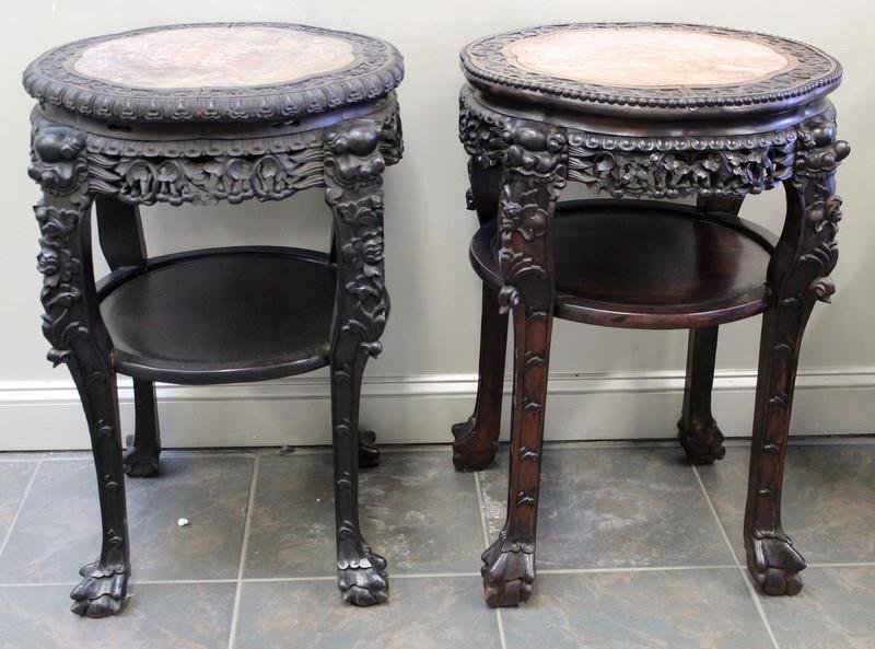 Two Chinese Hardwood Urn Stands.: With foo dogs and inset marble tops. From a Connecticut estate. Dimensions: 22" diameter x 32" high. Condition: Some shrinkage to medial shelf; finish on one stand is worn, different shades.