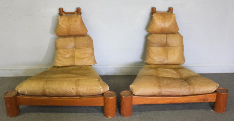 Pair Of Midcentury Leather Upholstered Low Chairs: Solid leather strapping and upholstered with 3 cushions. Possibly Brazilian. From a New Rochelle, NY estate. Dimensions: 41" wide X 37" deep x 34" high. Condition: Good, scuffs, scratches.