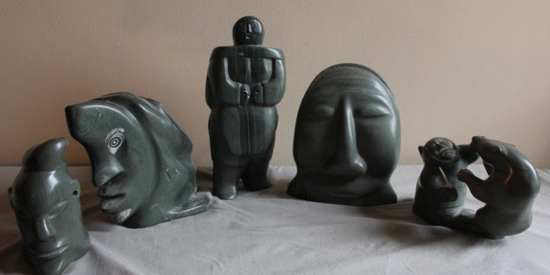 5 Piece Inuit Lot.: 5 pieces. Includes a carving of a small face, a double sided head, a figure with child, a face, and a hunter fighting a bear. From a West 57th St. NYC estate. Dimensions: Head - 15" h; Figure - 13.5" 