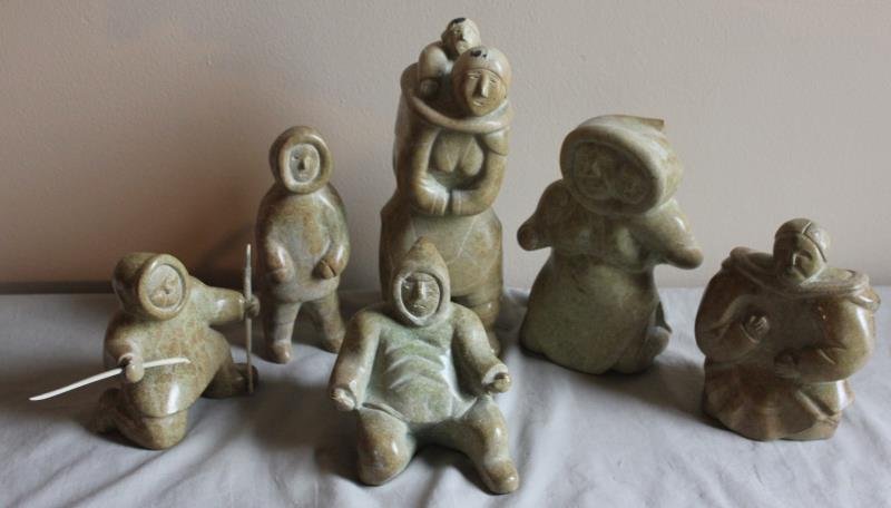 6 Piece Inuit Figure Lot.: Includes a hunter with spear, a single figure, a figure with child, a woman with child, an elderly woman, and a seated figure. From a West 57th St. NYC estate. Dimensions: Range from 10.75" h to 7" h.
