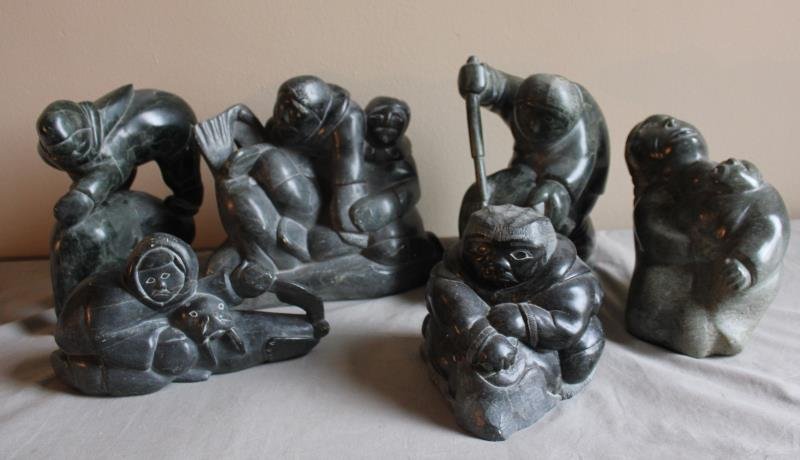 6 Piece Figural Inuit Lot.: Includes a woman and baby - 8"w x 10" h, a man on sea lion - 9" w x 10.5" h, a figural grouping - 12" w x 10" h, a hunter with walrus - 11" w x 6" h, a hunter spearing seal - 11" w x 10.5" h, and an e