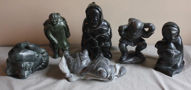 6 Piece Inuit Lot.: Includes an animal grouping - 11" w x 9" h, a mother and baby - 6" w x 12" h, a hunter - 8" w x 14" h, men on ice - 14" w x 6.5" h, a man with bag - 9" w x 11" h, and a kneeling figure - 9" w x 12" h.