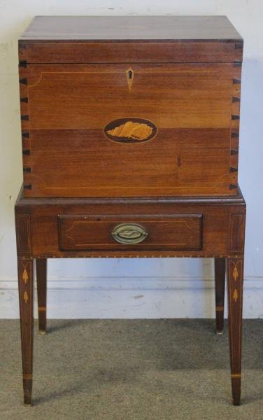 Hepplewhite Style Cellarette on Stand.: Late 19th, early 20th century bench made. With divided interior. Conch and other lays. From a Mamaroneck, NY estate. Dimensions: 21" w x 17" d x 36" h. Condition: Good.