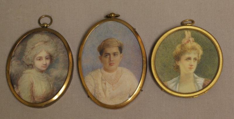 3 Portrait Miniatures on Bone/Ivory.: Young woman with big brown eyes and a bow in her silver hair set in a gilt locket frame, 2 1/2" high. Young Moroccan (?) boy in a cap and pearl necklace, set in gilt locket frame, 2 3/4" high. Young w