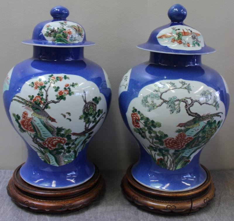 Pair of Chinese Blue and White Ginger Jars Style: Covered Urns. On hardwood bases. Circa mid 20th century. From an East. 62nd St., NYC estate. Dimensions: porcelain only - 10" w x 17.5" h. Condition: Good. "Lyrical Space" - Ruth Claremon