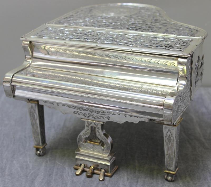 JUDAICA. Very Fine and Impressive Sterling Menorah: in the Form of a Piano. The keys, lid, and other parts of the piano are hinged, moveable, and removable. The foot pedal is free from piano .The piano is made by Shuki Freiman, signed, "SF," and "925."