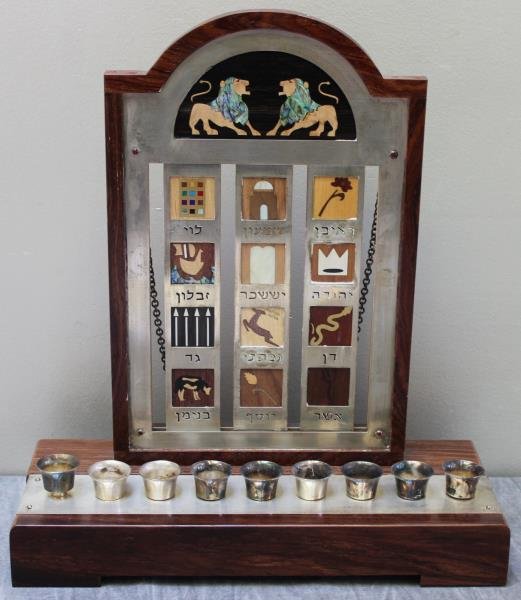 JUDAICA. A. Loreli & Alex Gruss or Studio Gruss: Menorah. Comprised of a silver plaque and mixed wood samples. Signed on the reverse, "Gruss." From a Mamaroneck, NY estate. Dimensions: 13" w x 5" d x 14.75" h.