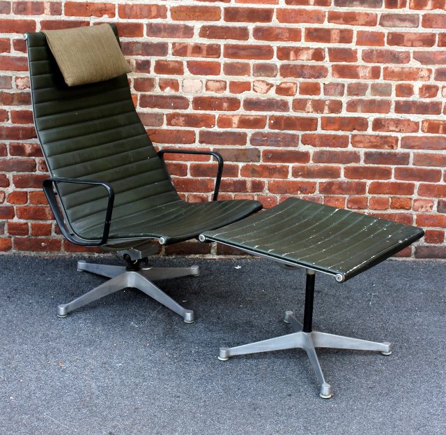Early Eames Aluminum Group Chair and Ottoman.: Highback chair with aluminum frame and original leather upholstery, attached hanging head rest and original leather ottoman. Imprinted to aluminum "Herman Miller." Designed by Ray & Charles Eames for 