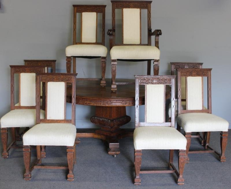 Carved Oak Dining Set: Table & 8 Chairs.: With 5 leaves. 1 arm chair with 5 side chairs. From a Mamaroneck, NY estate. Dimensions: Table - 60" diameter plus 5-12" leaves x 30" h; Chairs - 20" w x 21" d x 40" h.
