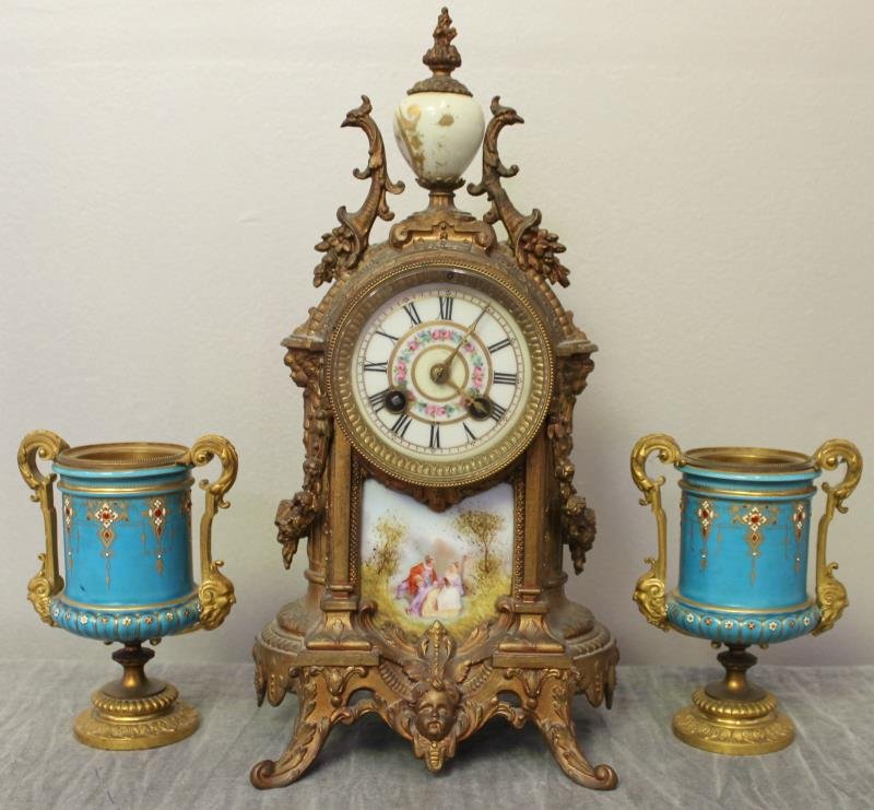 Garniture Set.: Clock with a pair of urns. From an Orangeburg, NY home. Dimensions: clock - 13.5" high; urns - 5.5" high.