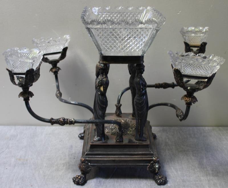 19th Cent Silverplate Figural Epergne Raised on: Claw Feet. A nice epergne with nice fine cut glass inserts. From an Englewood, NJ estate. Dimensions: 19" diam. x 13"w x 16"h approx. Condition: good, wear showing to silverplate.