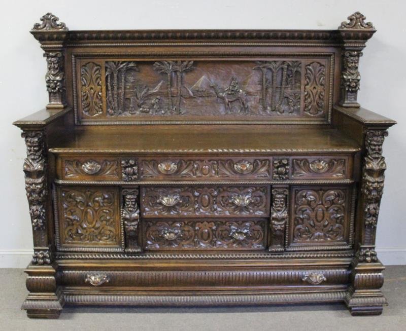 Unusual Oak Figural Carved Sideboard.: Most probably Horner. Carved with male figure pilasters, and an extremely unusual backsplash with Middle Eastern style carving. From a Larchmont, NY estate. Dimensions: 28" w x 43" w x 62" h. Conditio