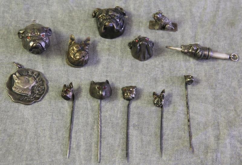 JEWELRY. Sterling Dog Jewelry Grouping.: Includes an unmarked, but surely silver, bulldog pendant with inlaid marcasite and ruby? cabochon eyes; an unmarked, but surely silver, bulldog head brooch; an unmarked bulldog head brooch; a sterling