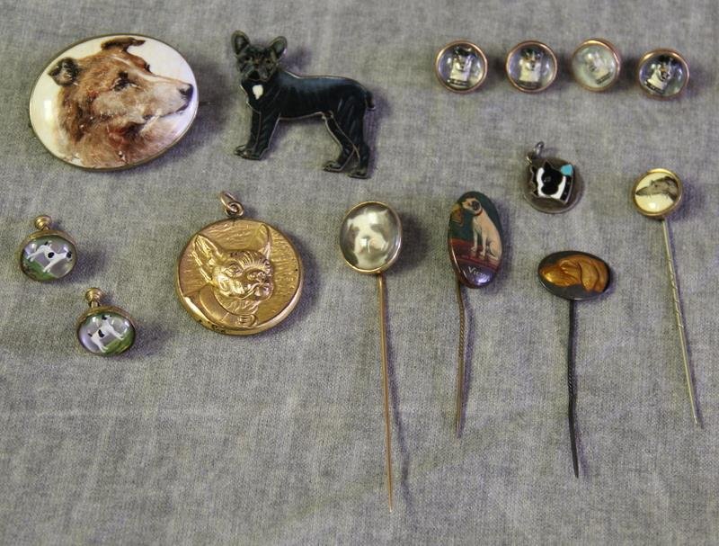 JEWELRY. Dog Jewelry Grouping.: Includes a S&BL French bulldog locket; an enamel decorated sterling French bulldog brooch; a hand painted porcelain plaque of a dog brooch - with craquelure and scratches; an enamel decorated stick pi