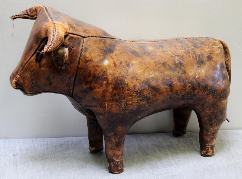 Vintage Abercrombie Leather Bull Footstool.: From an E. 72nd St., NYC estate. Dimensions: 15" w x28" d x 18" h. Condition: One horn with loss and split. Tail loose but present. Overall wear, scuffs, scratches, etc.
