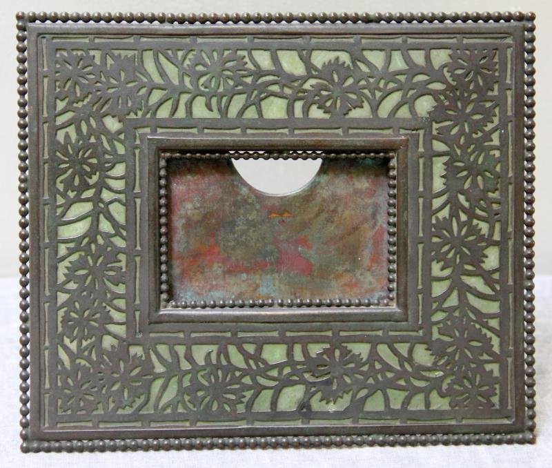 Tiffany Studios Frame.: Stamped, "Tiffany Studios New York" to backside of frame. From a Rye Brook, NY estate. Dimensions: 7.25" w x 6.125" h. Condition: With cracks to slag glass panels.