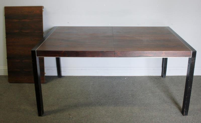 Midcentury Rosewood and Chrome Dining Table.: Possibly Milo Baughman rosewood top with chrome accent and black painted leg dining table. From an East Hampton, NY location. Dimensions: 60.5" w x 40" d x 28.75" h; one 20" leaf.