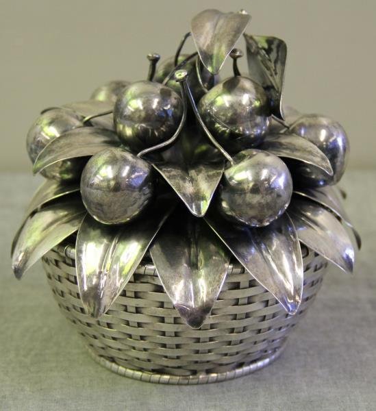 STERLING. Buccellati Silver Cherry Centerpiece.: Cherry and foliate form centerpiece. Signed, "Buccellati/Sterling/Italy". Accompanied by an apparently unmarked silver woven basket. Cherries weigh approx. 10.66 troy oz. From a Mamaroneck, NY estate.