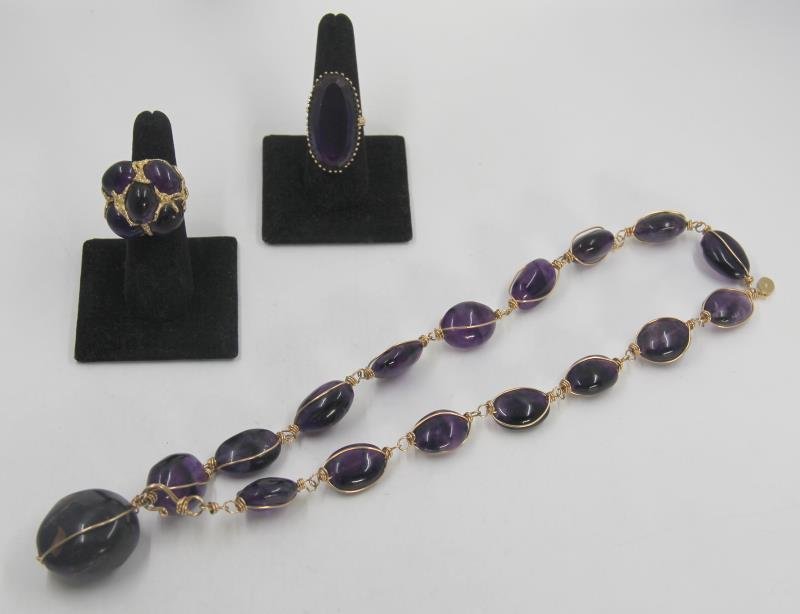 JEWELRY. Amethyst Jewelry Grouping.: Includes an 14kt yellow gold wire wrapped amethyst Dayne Duvall necklace; a 14kt yellow gold and amethyst cabochon ring; and an 18kt yellow gold and oblong faceted amethyst ring. Ring sizes: multi sto