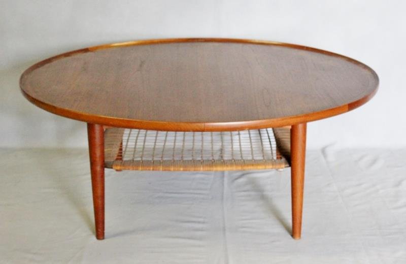 Midcentury Danish Teak Coffee Table with Caning.: Rattan lower tier. Manufactured by Selig. Round teak coffee table with Danish control button to underside. Slight lip to table top and tapered legs. From a Long Island, NY estate. Dimensions: 32" diam