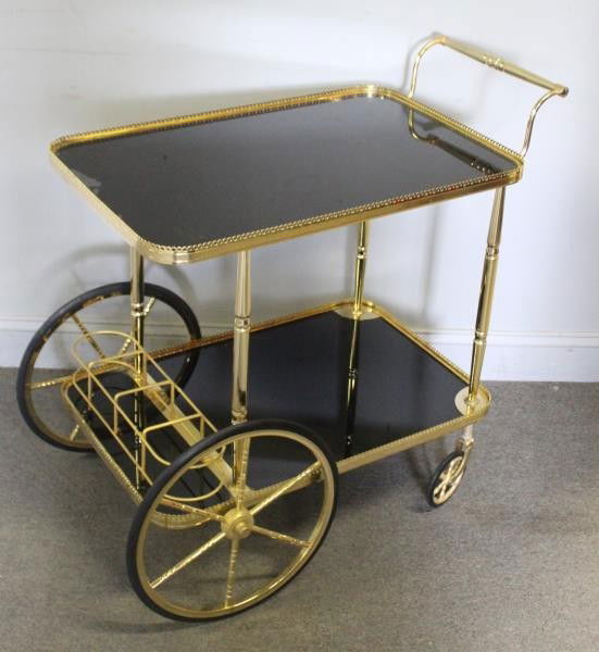 Decorative Brass and Black Glass Bar Cart.: Unmarked. Black glass inserts and brass finished frame. From a Long Island, NY estate. Dimensions: 19" w x 31" d x 32" h. Condition: Good with minor pressure ? spotting to glass underside at top.