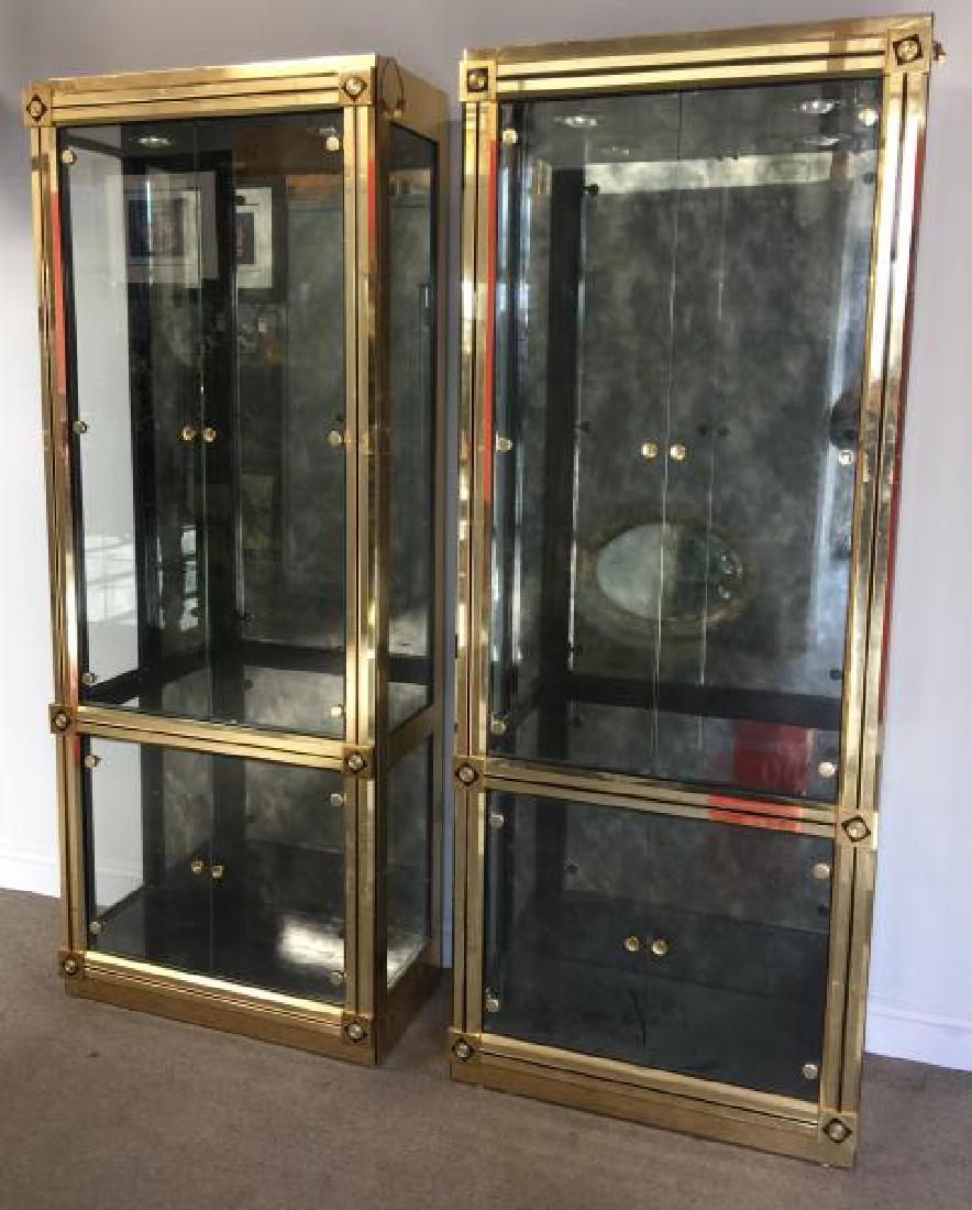 Modern Pair of Brass Display Cabinets.: With black finish accents and four doors. Single display unit with two larger doors over two smaller doors. Antique style mirror backing and glass shelves. Dimmable? top lighting. From a Stamford, CT 