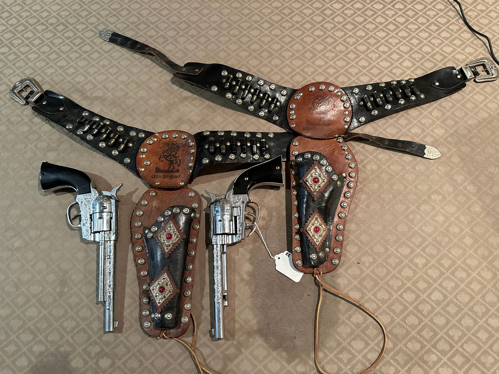 (2) WILD BILL HICKOK CAP GUNS AND HOLSTERS: AS SHOWN IF YOU HAVE ANY QUESTIONS PLEASE ASK