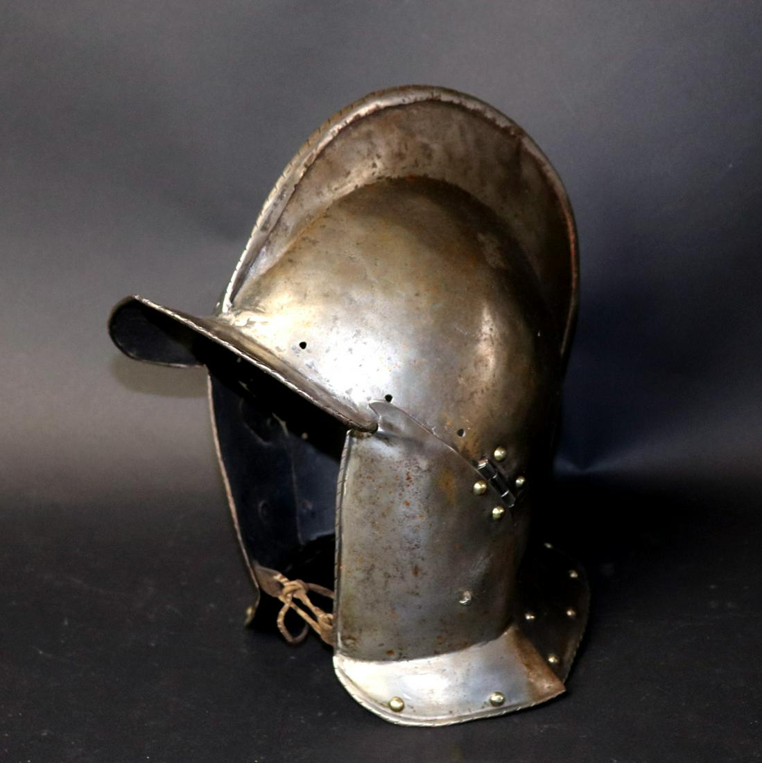 16th C. German Burgonet Helmet: Late 16th century Burgonet helmet with replaced leather and rivets. High Comb with two piece skull and hinged cheek plates, circa 1580 or later. 12" H x 12" L x 7.5" WCalifornia arms collector 2007