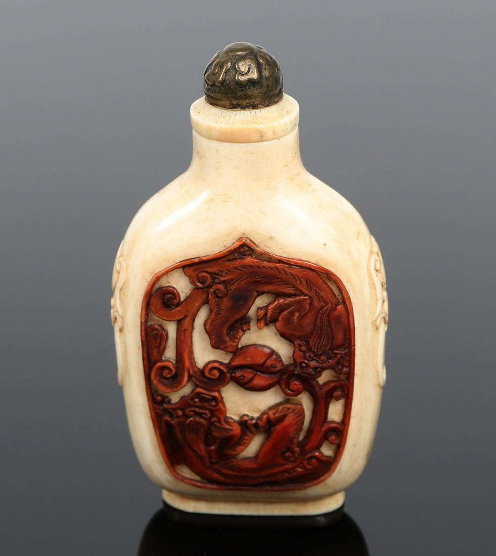 Chinese Cast Snuff Bottle: Imitating bone, this snuff bottle has beast like mock handles to each shoulder. Two cats in yin-yang positions face each other. Metal topped stopper and metal spoon still attached, four character mark