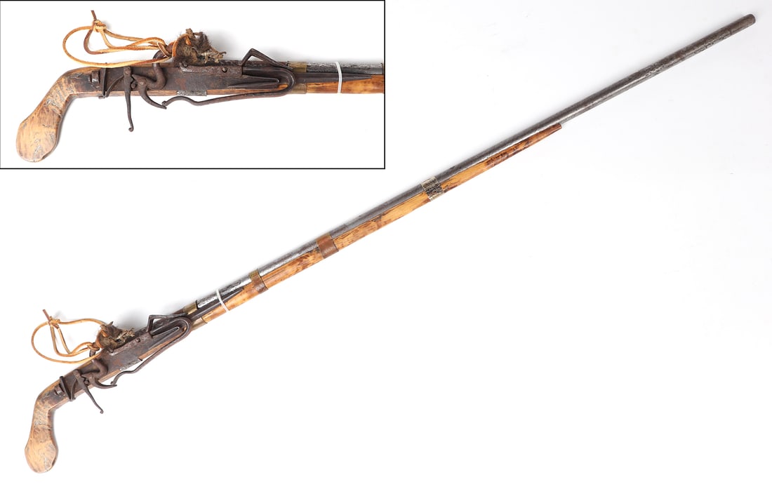 Hmong "Monkey Gun" Light Musket Flintlock Rifle, 1800s and Later: Musket of a light and elegant form in light maple colored wood. Slender circular barrel, bright copper bands, and fur talisman still affixed to the leather strap. Size overall 40 1/4" L, barrel 30", 3
