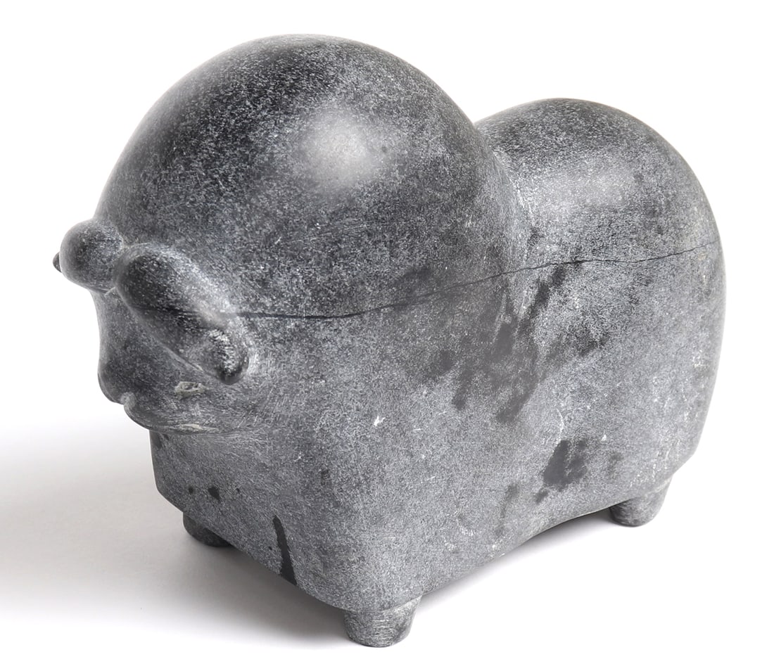 Heavy Inuit Carved Muskox, Camille Iquliq, Qamani'tuaq 1962-2005: Very heavy Inuit carved stone muskox with large horns, incised eyes, snout and mouth. Carved from a single piece of dark gray stone with four pegged feet. White pigment remains to one eye. Faintly etc