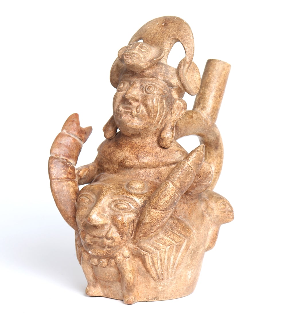 Moche Deity Holding a Crab, Stirrup Vessel North Coast 900-1250CE: South America, Peru, North Coast, Moche Culture 900-1250CE. Feline fanged Crab God, an exceptional interpretation of the Crab God in a transformative state wearing a feline head headdress with large e