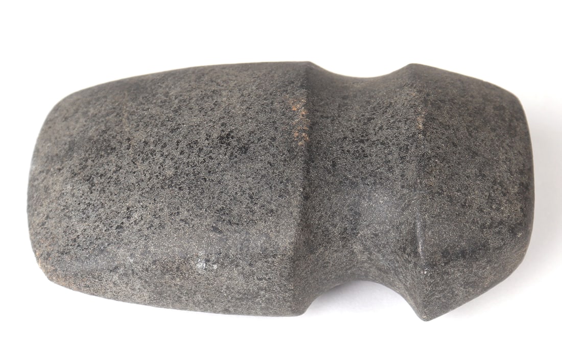 Native American Stone Axe Head: Native American stone axe head with a carved recess of typical form to secure. Ancient tools and weapons made by Indigenous peoples of North America. These stone implements were essential for various